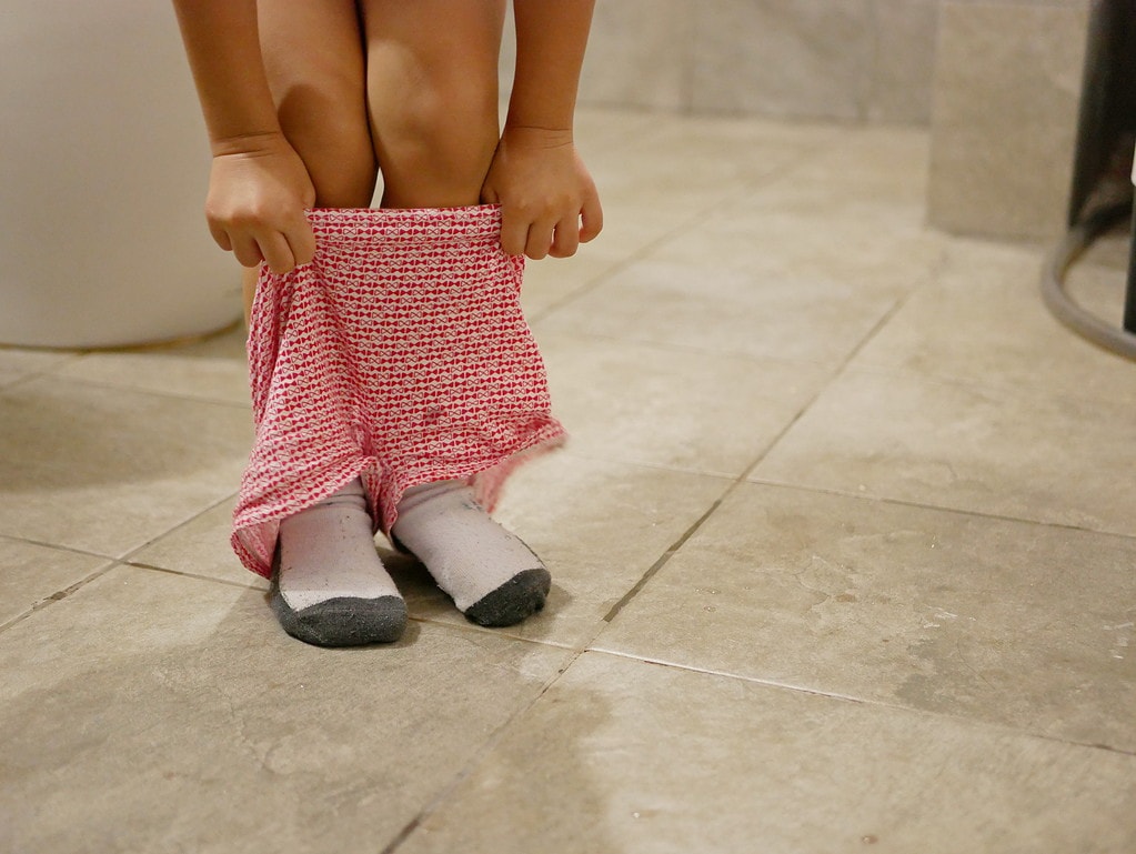 Photo of a child feet pulling up pants during potty training
